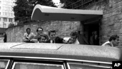 FILE - In this March 30, 1981, photo, U.S. president Ronald Reagan, center, is shown being shoved into his limousine by secret service agents after being shot outside a Washington hotel. The man who shot Reagan is scheduled to leave a Washington mental hospital