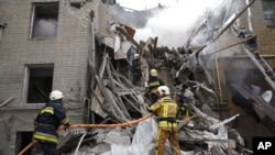 Ukrainian firefighters work on a destroyed building after a Russian rocket attack in center Kharkiv, Ukraine, Sept. 6, 2022.