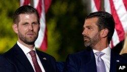 Foto Achiv: Eric Trump ak Donald Trump Jr. tann papa yo Donald Trump sou gazon Sid Lamezonblanch la, 27 Out, 2020. 