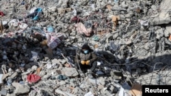 A man sits on the rubble, in the aftermath of a deadly earthquake in Kahramanmaras, Turkey, Feb. 15, 2023. 