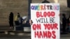 FILE - A protester outside the Kansas Statehouse holds a sign after a rally for transgender rights on the Transgender Day of Visibility, March 31, 2023, in Topeka, Kan.