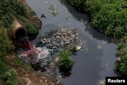 Bangladeş'te tekstil boyası atıkları yüzünden suların kırmızıya boyandığı Buriganga nehri.