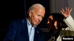 Vice President Kamala Harris speaks with President Joe Biden on a White House balcony during an Independence Day celebration in Washington, July 4, 2024. 