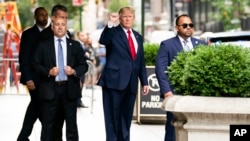 Ansyen Prezidan Donald Trump salye moun kap gade nan moman lap kite Trump Tower, Mekredi, 10 Out, 2022 nan Nouyok, pou'l al nan biwo komise gouvenman an. 