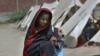 Flood victim Rajul Noor walks towards her tent school at a relief camp, in Dadu district, Pakistan, Sept. 23, 2022. (AP Photo/Fareed Khan)
