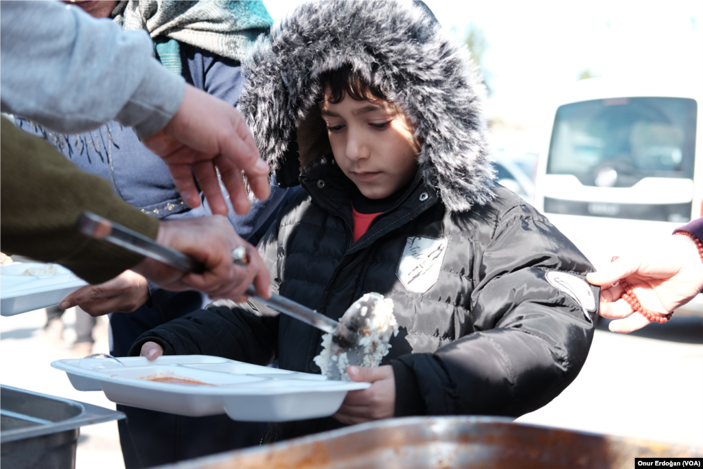 Kampta sıcak yemek, su, süt, battaniye ve bağışla gelen çeşitli kıyafetler dağıtılıyor.&nbsp;