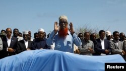 Relatives and Somali government officials pray near the slain body of Amina Mohamed Abdi, a vocal critic of the government, who was killed in a suicide explosion in Beledweyne, at the Adan Abdulle International Airport international in Mogadishu, Somalia,