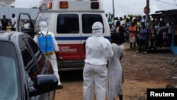 Nhân viên y tế đưa phụ nữ bị nghi nhiễm Ebola lên xe cứu thương tại Monrovia, Liberia, ngày 15/9/2014.