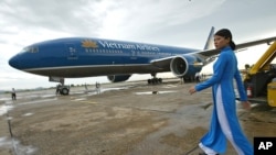 Một chiếc máy báy và nhân viên của Hãng hàng không Quốc gia Việt Nam (Vietnam Airlines).