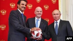 Quốc vương Qatar Sheikh Tamim bin Hamad Al-Thani (trái), nhận quả bóng, biểu tượng đăng cai World Cup lần tới, từ tay Tổng thống Nga Vladimir Putin (phải) và Chủ tịch FIFA Gianni Infantino. 