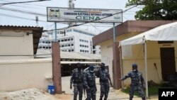 Des policiers sortent des locaux de la Commission électorale nationale autonome (CENA) alors que le dépouillement des votes commence à Cotonou, au Bénin le 12 avril 2021, après les élections présidentielles du pays. (Photo PIUS UTOMI EKPEI / AFP)