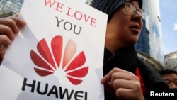 Một người Trung Quốc bày tỏ tình yêu đối với tập đoàn Huawei bên ngoài tòa án ở Canada.