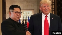 Tổng thống Mỹ Donald Trump và lãnh tụ Triều Tiên Kim Jong Un bắt tay sau khi ký tuyên bố chung, 12/6/2018.