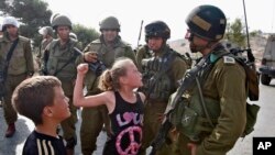 2 Kasım 2012 tarihli bu fotoğrafta, o zamanlar 12 yaşında olan Ahed Tamimi, Batı Şeria'nın Nabi Salih köyünde bir protesto sırasında bir İsrail askerine yumruk atmaya çalışıyor