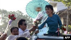 Lãnh tụ dân chủ Aung San Suu Kyi nhận được hoa từ người ủng hộ trên đường đi vận động tranh cử ở thị trấn Thone-Gwa ở Rangoon, Miến Điện, ngày 26/2/2012