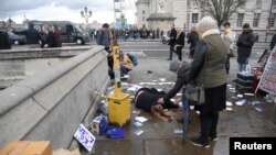 A woman lies injured after a shooting incident on Westminster Bridge in London, March 22, 2017. 