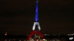 Tháp Eiffel được chiếu sáng màu quốc kỳ xanh, trắng, đỏ của Pháp để vinh danh các nạn nhân của các vụ tấn công khủng bố ở Paris, ngày 16/11/2015.