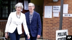 Thủ tướng Anh Theresa May rời phòng phiếu cùng chồng sau khi bỏ phiếu trong cuộc tổng tuyển cử tại điểm bỏ phiếu Maidenhead, xứ Anh, ngày 8 tháng 6, 2017.