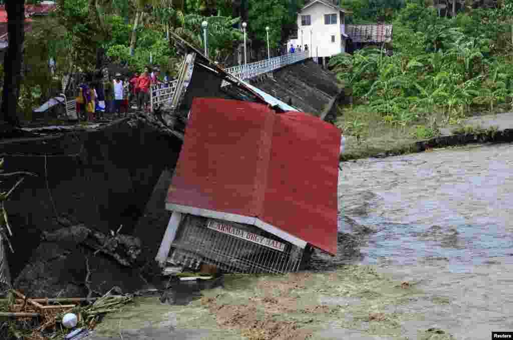 Cư dân đứng nhìn cảnh tượng đổ nát sau trận bão Haiyan tại tỉnh Iloilo ở miền trung Philippines, ngày 9/11/2013.