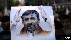 Một ủng hộ viên của nhóm Hezbollah cầm hình ông Ahmadinejad trong cuộc tập họp đón chào ông đến thăm khu ngoại ô Beirut