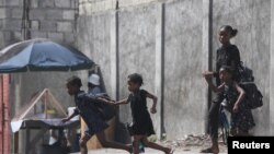 A woman and three children flee their home amid gang violence, in Port-au-Prince, Haiti, Oct. 20, 2024.