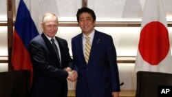 Tổng thống Nga Vladimir Putin, trái, bắt tay Thủ tướng Nhật Shinzo Abe trước khi họp ở Nagato, miền tây Nhật Bản, 15/12/2016.