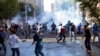 FILE - In this Oct. 7, 2014, photo, Turkish riot police use water cannons and tear gas to disperse people protesting against Turkey's policy in Syria, in Diyarbakir, Turkey. 