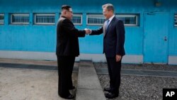 Lãnh tụ Bắc Hàn Kim Jong Un bắt tay Tổng thống Hàn Quốc Moon Jae-in qua lằn ranh quân sự trên biên giới, trước khi lần đầu đặt chân tới miền nam hôm 27/4.