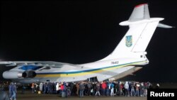 Relatives of Ukrainian citizens, who were exchanged during a prisoner swap, surround an aircraft during a welcoming ceremony at Boryspil International Airport, outside Kyiv, Ukraine, Dec. 29, 2019.