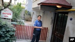 Ev hapsinde tutulan Rahip Brunson'un İzmir'deki evinin kapısının önünde bekleyen polis memuru