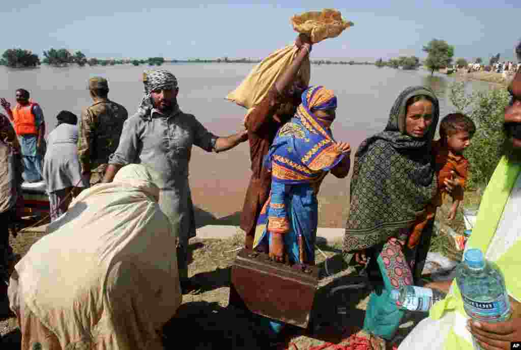 Dân làng Pakistan bị ảnh hưởng bởi lũ lụt&nbsp;được đưa tới nơi trú ẩn an toàn ở Pindi Bhatian, 105 km (65 dặm) đông bắc Lahore, Pakistan, ngày 8/9/2014.