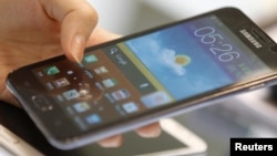 A customer tries the Samsung Galaxy Note smartphone at a store in Seoul August 26, 2012. Apple Inc's decisive triumph over Samsung Electronics in the most closely watched patent trial in years could open the door for Microsoft Corp to finally hop on board