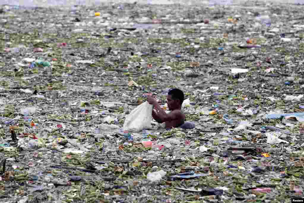 Một người Philippines thu nhặt plastic v&agrave; c&aacute;c m&oacute;n c&oacute; thể t&aacute;i chế trong đ&aacute;m r&aacute;c đổ ra vịnh Manila sau b&atilde;o Saola, 30/7/2012.