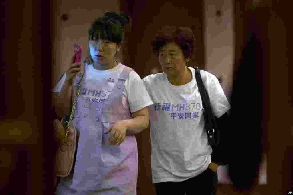 Relatives of Chinese passengers aboard missing flight MH370 walk out from a meeting room in a hotel in Beijing, March 23, 2014.