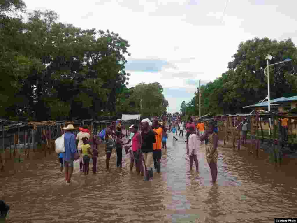 Moun ki kanpe nan yon lari ki&nbsp;anvayi ak dlo&nbsp;ki konn sevi kom yon&nbsp;mache&nbsp;nan tan nomal, nan Wanament,&nbsp;depatman nodes peyi Dayiti, 8 septanm 2017. &nbsp;