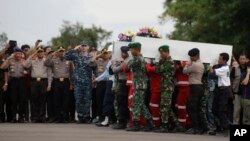 Các thành viên trong Lực lượng Tìm kiếm Cứu hộ Quốc gia Indonesia khiêng quan tài các nạn nhân chuyến bay AirAsia 8501 tại sân bay ở Pangkalan Bun, Indonesia, ngày 2/1/2015.