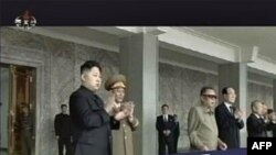 Ông Kim Jong-Il và con trai Kim Jong-un (trái) xem diễn hành tại quảng trường ở Bình Nhưỡng