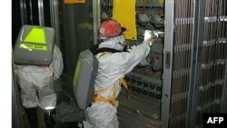 Các công nhân mặc đồ bảo hộ bên trong nhà máy điện hạt nhân bị hư hại Fukushima Daiichi, ngày 10 tháng 5, 2011