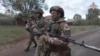 FILE - In this photo taken from video released by the Russian Defense Ministry on Oct. 24, 2024, Russian soldiers patrol in a village on Russia's border with Ukraine. (Russian Defense Ministry Press Service photo via AP)