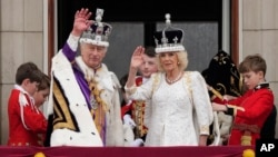 Vua Charles III của Vương quốc Anh và Nữ hoàng Camilla vẫy tay chào đám đông từ ban công của Cung điện Buckingham sau lễ đăng quang ở London, ngày 6 tháng 5 năm 2023.