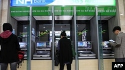 Khách hàng sử dụng máy ATM tại Ngân hàng Nonghyup ở Seoul, ngày 3/5/2011