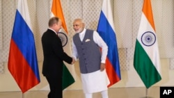 Indian Prime Minister Narendra Modi, right, shakes hand with Russian President Vladimir Putin prior to their bilateral meeting, in Goa, India, Oct. 15, 2016. The two leaders signed several agreements as part of apparent efforts aimed at rejuvenating a rel