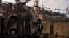 A worker walks in front of a transformer which was destroyed after a recent Russian missile attack at DTEK's power plant in Ukraine, Nov. 28, 2024.