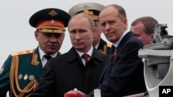 Tổng thống Nga Vladimir Putin cùng với Bộ trưởng Quốc phòng Sergei Shoigu (trái) và Giám đốc Cơ quan An ninh Alexander Bortnikov (phải) trên 1 chiếc thuyền ở Sevastopol, Crimea, 9/5/2014.