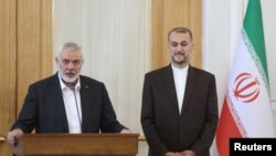 Palestinian group Hamas' top leader, Ismail Haniyeh and Iran's Foreign Minister Hossein Amir Abdollahian attend a press conference in Tehran