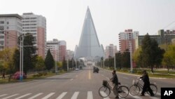 Người qua đường trước mặt khách sạn Ryugyong ở Bình Nhưỡng, Triều Tiên (ảnh chụp ngày 28/4/2020)