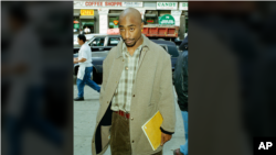 Rapper Tupac Shakur holds a notebook at New York State Supreme Court in Manhattan