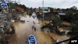 Nhân viên cứu hộ dùng thuyền cao su đi tìm người mất tích sau lũ quét tại thành phố Cagayan de Oro, Philippines, ngày 17 tháng 12, 2011