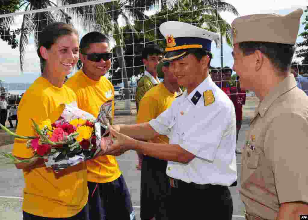 Đà Nẵng, Việt Nam (16/7/2011) Hạ sĩ pháo thủ Ashley Cordray, làm việc trên khu trục hạm USS Preble (DDG 88), nhận hoa do một sĩ quan Việt Nam tặng trước trận đấu bóng chuyền trong Hoạt động Giao lưu Hải quân (NEA) với Việt Nam năm 2011. (Bản quyền của Hải