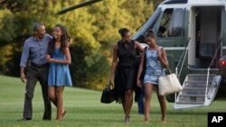 Từ trái qua, Tổng thống Barack Obama với con gái lớn Malia và Đệ nhất phu nhân Michelle Obama bên cạnh con gái út Sasha, đi bộ từ máy bay trực thăng Marine One băng qua Bãi cỏ Nam của Tòa Bạch Ốc ở Washington, ngày 23 tháng 8, 2015.